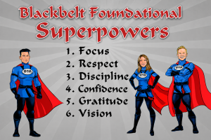 Title Text: Large red text at the top reads, "Blackbelt Foundational Superpowers". Numbered List: A central list features six items: Focus Respect Discipline Confidence Gratitude Vision Characters: Three illustrated superhero characters dressed in blue suits with red capes and black belts frame the list (one on the left, two on the right), all wearing uniforms bearing the "KMMA" logo.