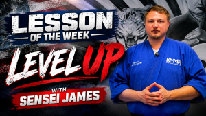 YouTube video thumbnail titled "Lesson of the Week: Level Up with Sensei James," featuring Sensei James in a blue uniform against a graphic background with an American flag, tiger illustration, and bold text