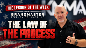Promotional graphic titled "The Lesson of the Week with Grandmaster Stephen Del Castillo: The Law of the Process," featuring Grandmaster Stephen Del Castillo gesturing as he speaks in front of an American flag background.
