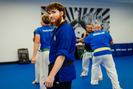 Shihan Winston grinning at camera on the Dojo mat.